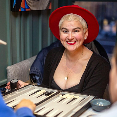 Woman in hat playing backgammon